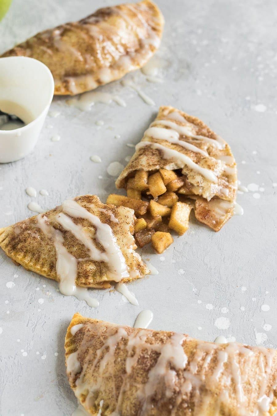 These baked apple pie empanadas with a buttery brown sugar apple filling and a spiced rum icing drizzle are the perfect party snack!