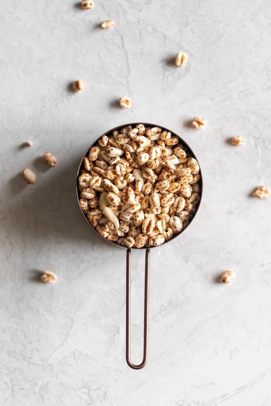 a measuring cup with puffed wheat cereal