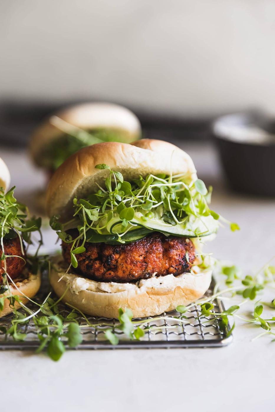 Easy-to-make, smoky, blackened salmon burgers made with smoked paprika, a pinch of cayenne, cumin, oregano and a queso fresco cream cheese spread!