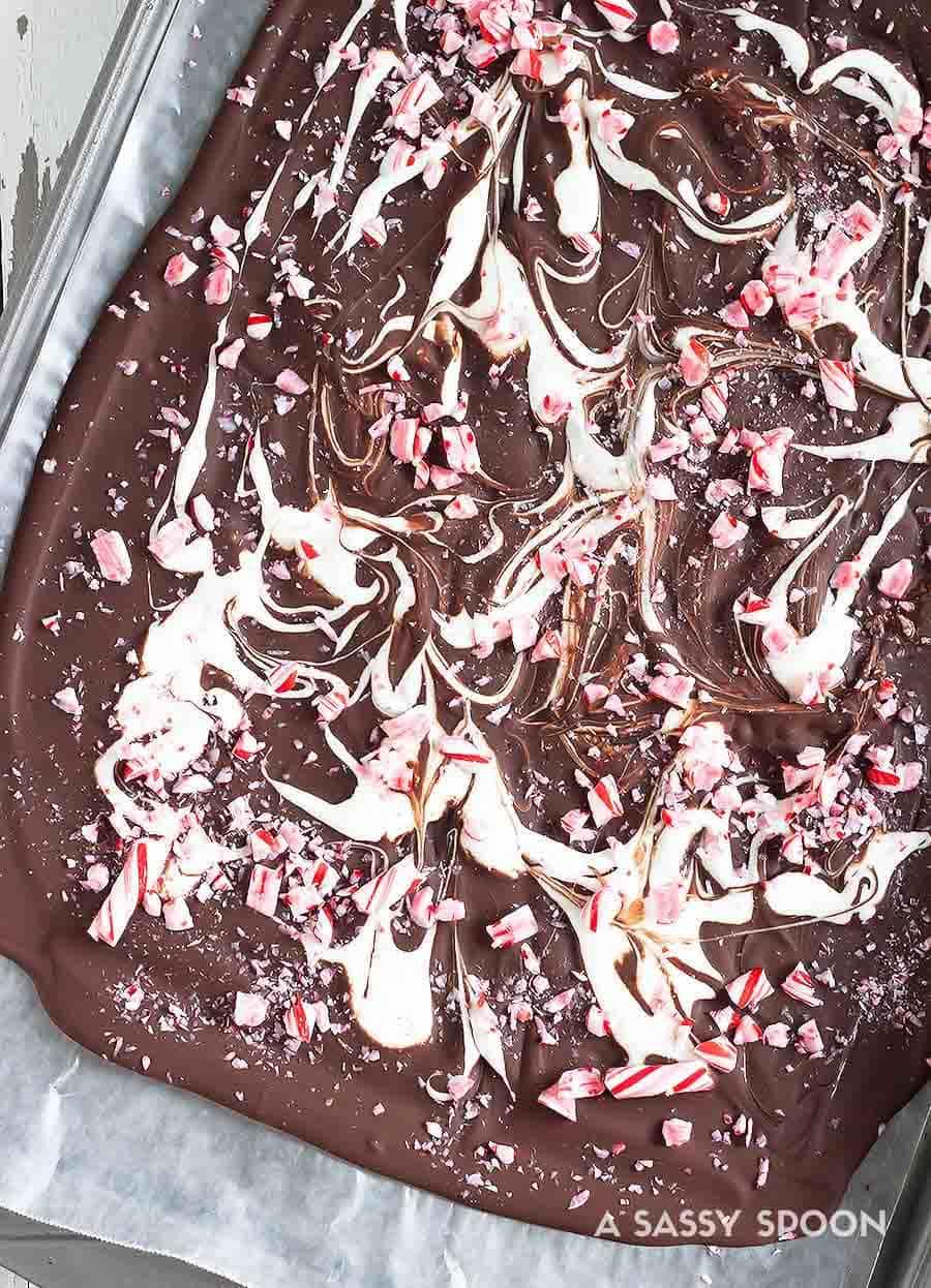 Sleigh the holidays with Boozy Marshmallow Peppermint Bark! Melted marshmallow mixed with peppermint schnapps, swirled on melted dark chocolate then topped with crushed candy canes.