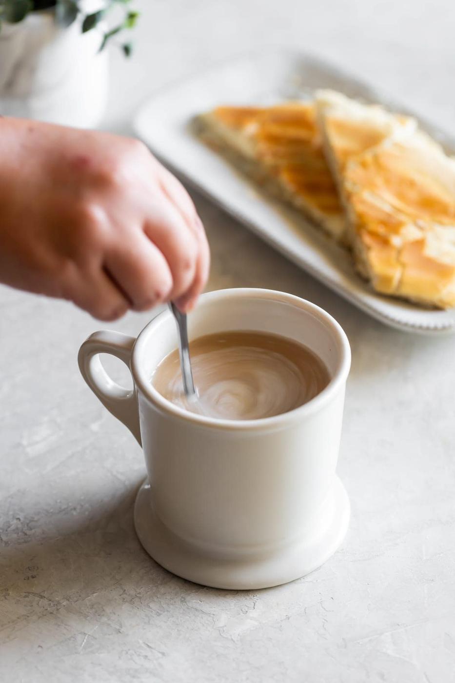cuban coffee being stirred into the hot whole milk