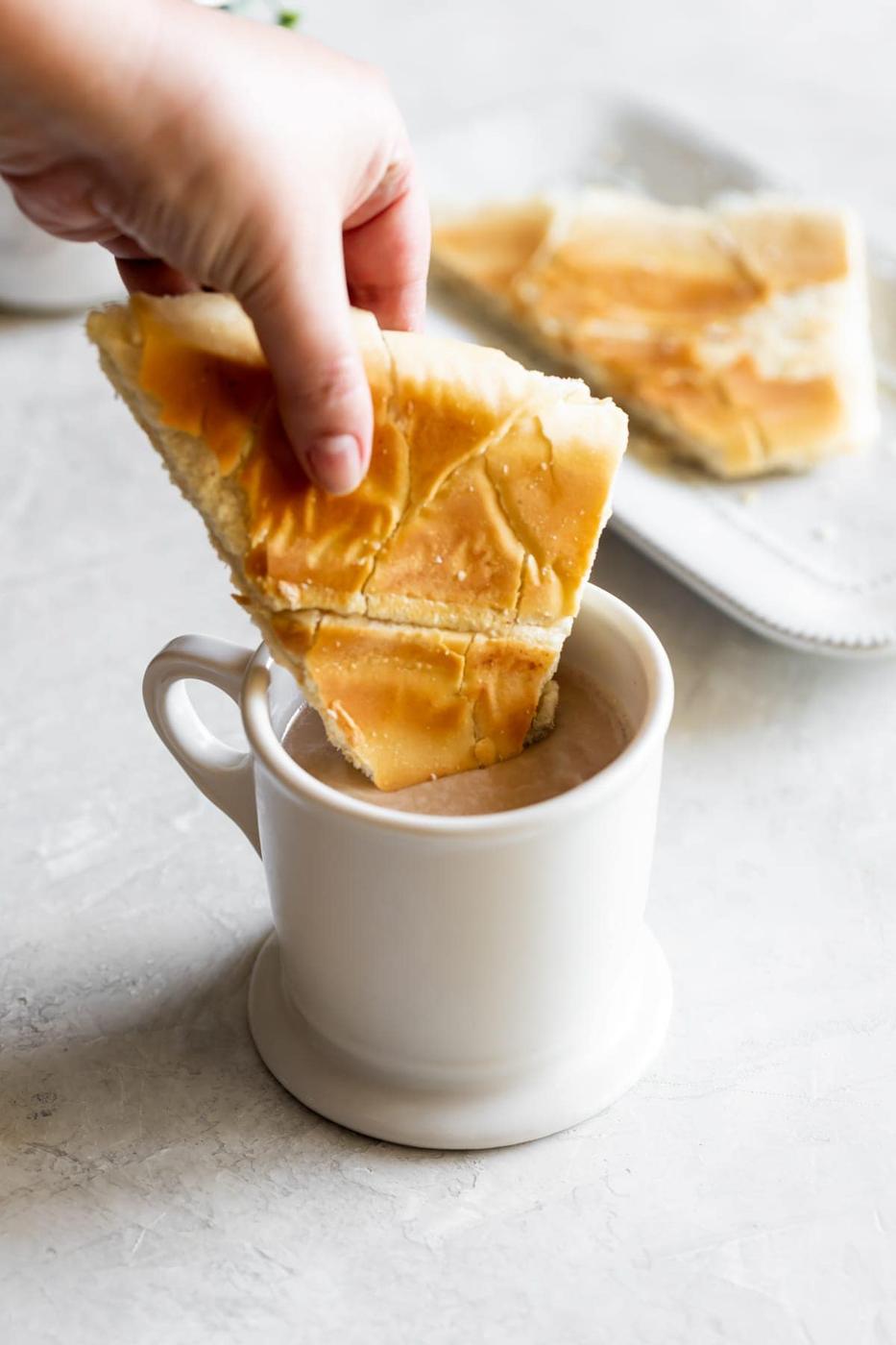 Cuban toast being dipped into cafe con leche
