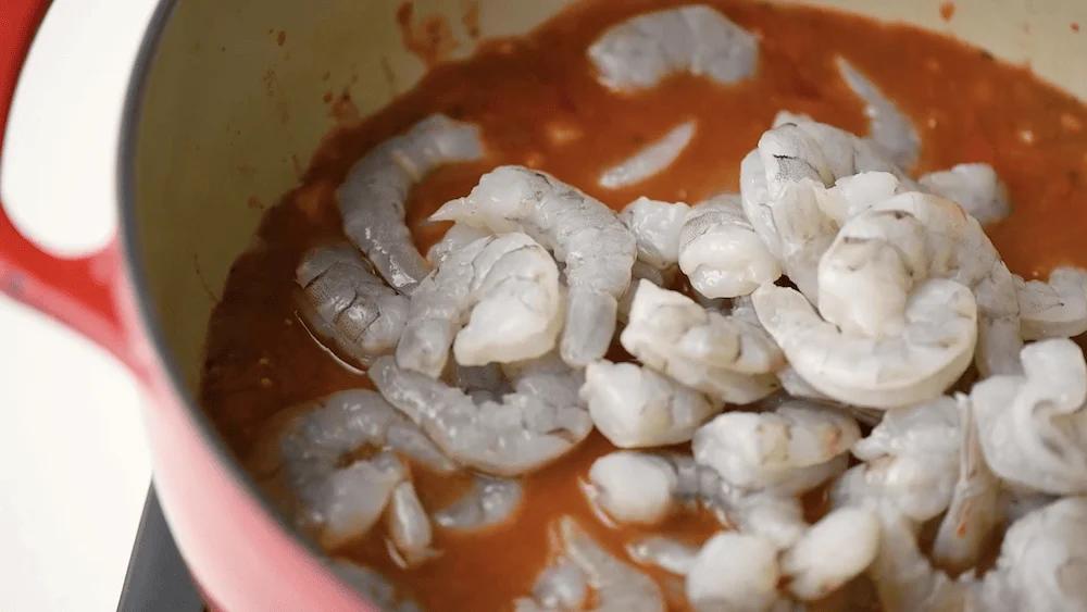 adding in the shrimp to the tomato-based sauce for the camarones enchilados