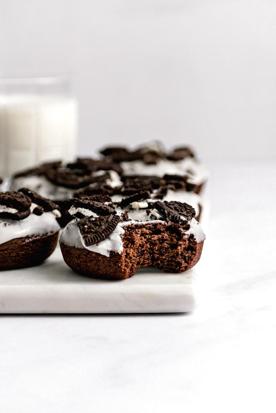 cookies and cream chocolate oreo donuts on a marble slab with milk