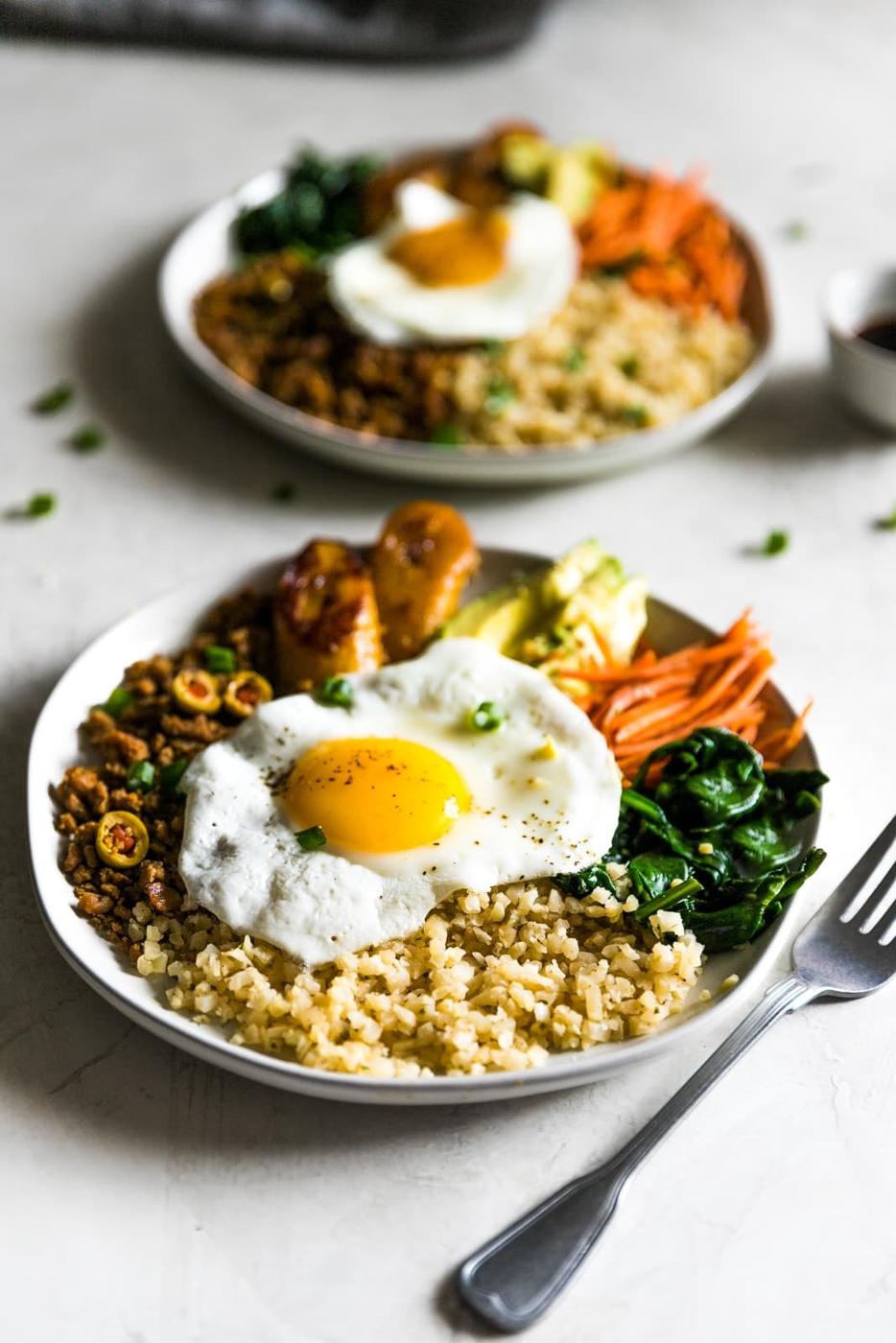 Inspired by Korean bibimbap, this healthy-ish Cuban bibimbap bowl has ground turkey (picadillo), seasoned cauliflower rice, sautéed garlic spinach, carrots, avocado, and sweet plantains. Colorful, flavorful and delicious!