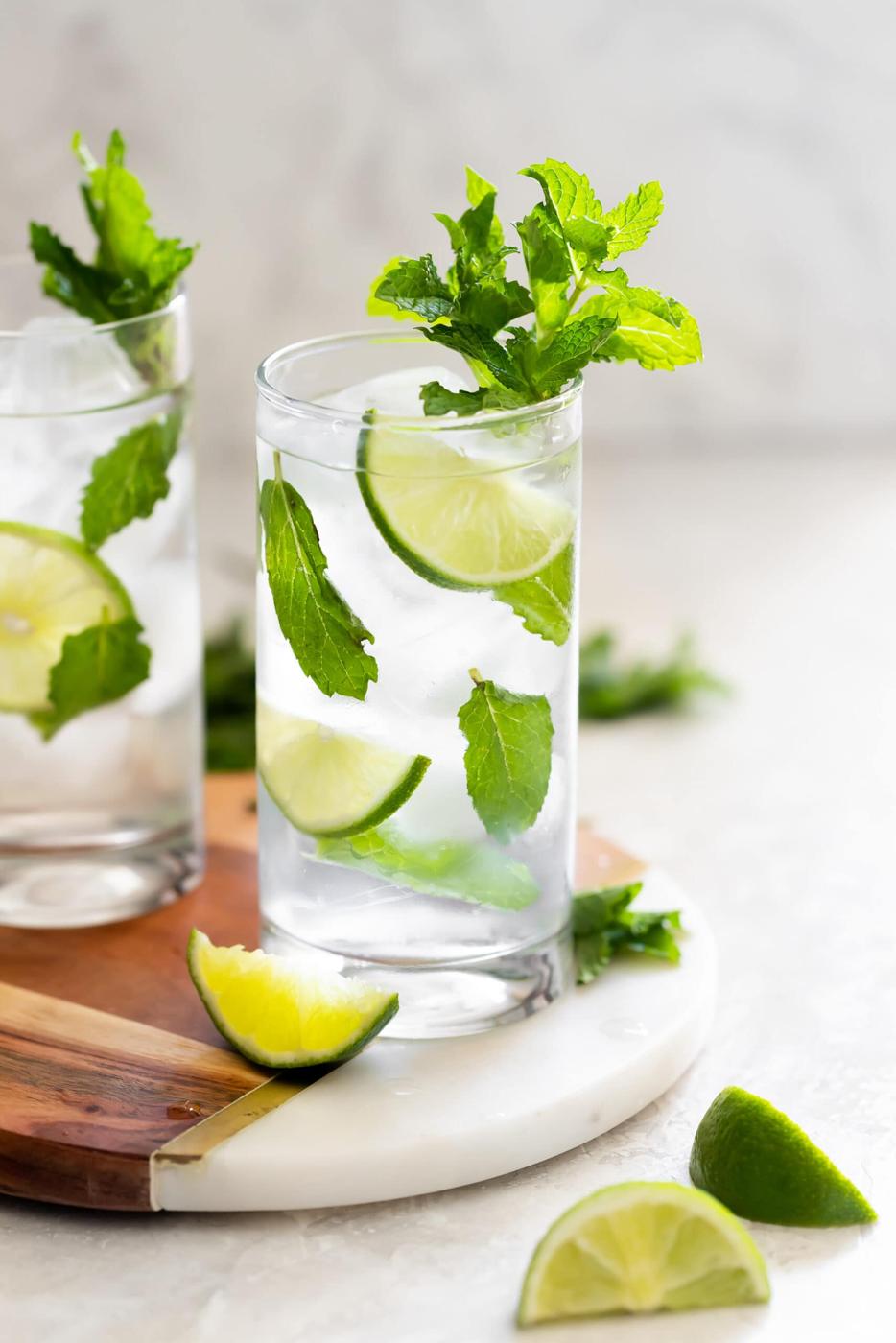 tall highball glass with mint, sugar, cuban rum, and fresh lime