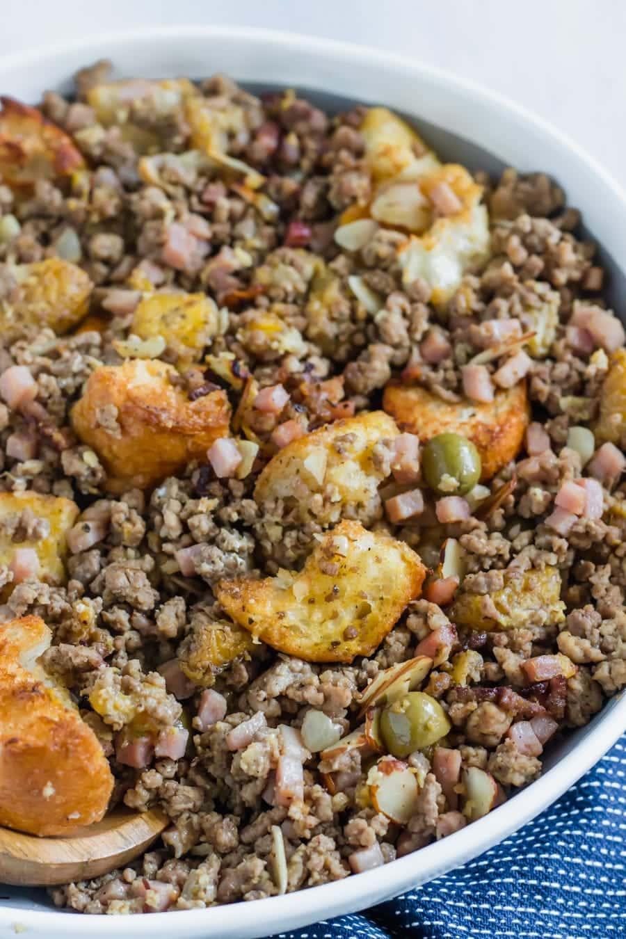 Cubes of toasty French bread mixed with ground beef, ground pork, diced ham, herbs, spices, sliced almonds, chopped olives, and sweet plantains! The BEST stuffing you'll ever try!