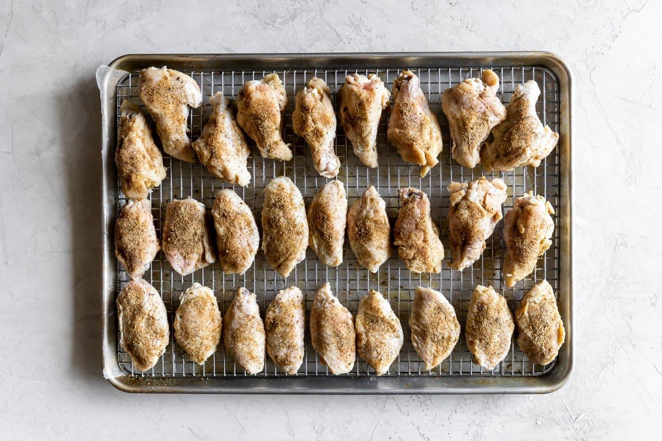 chicken wings on a wire rack on a baking sheet before baking in the oven