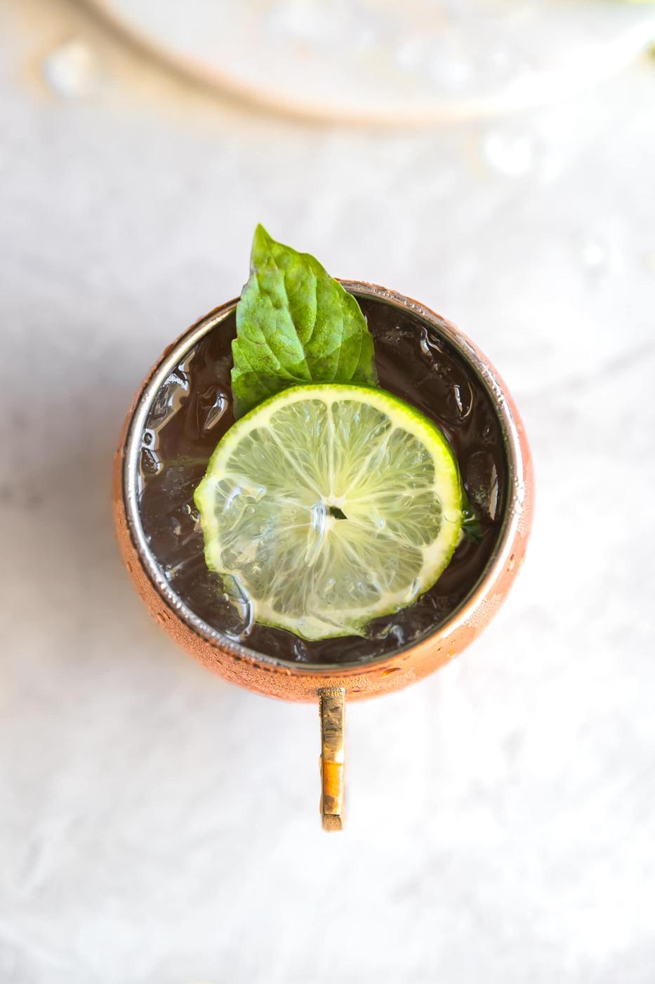 Guava Basil Moscow Mule. A twist to the traditional refreshing Vodka cocktail made with spicy ginger beer, guava nectar, fresh lime and sweet basil. Delicious drink for any time of year!
