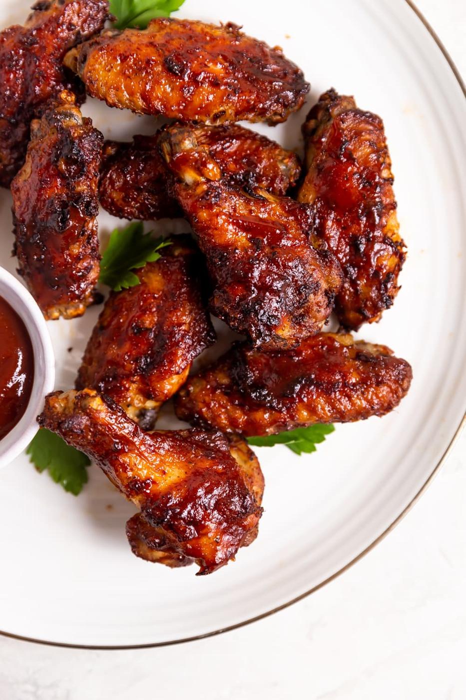 crispy chicken wings glazed with tangy guava bbq sauce on a white plate
