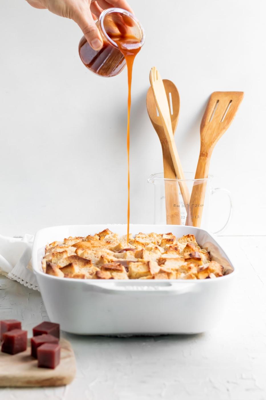 pouring the guava caramel over the bread pudding