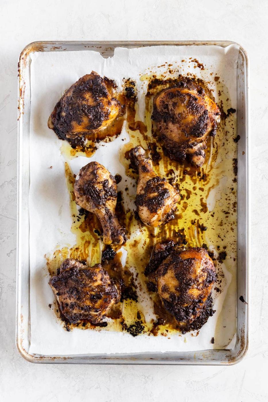 chicken cooked with jerk marinade on a baking sheet right out of the oven