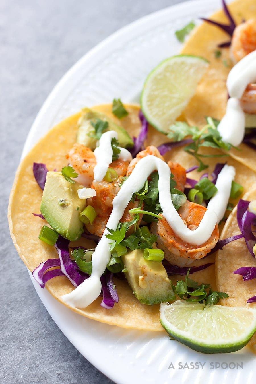 Tacos with shrimp marinated with tequila, lime juice, chili powder then topped with red cabbage, avocado, cilantro and a drizzle of sour cream!
