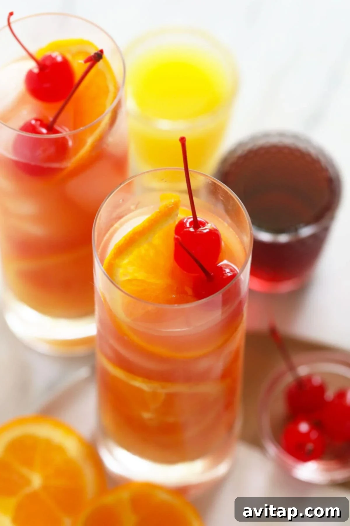Two perfectly prepared Sex on the Beach cocktails, garnished with cherries and orange slices, ready to be enjoyed.