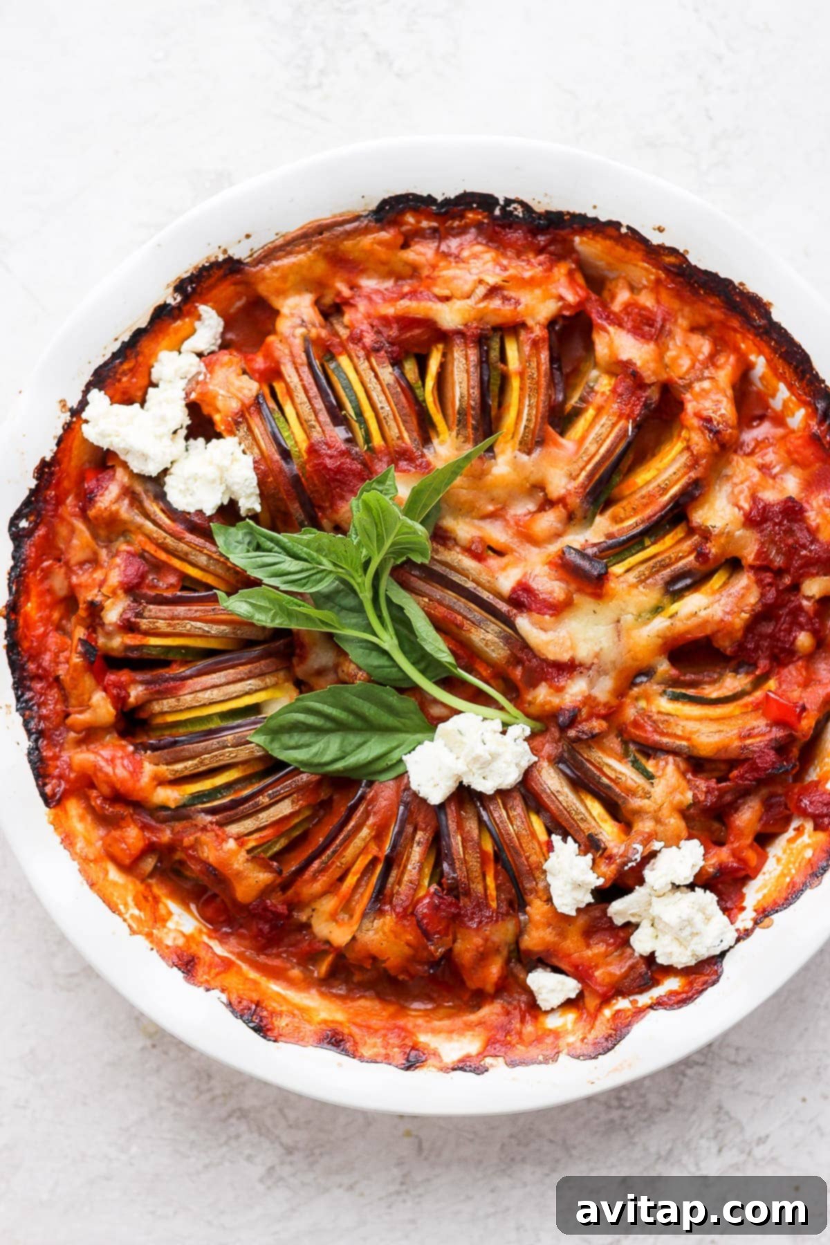 Beautifully arranged ratatouille in a round baking dish, showcasing colorful layers of vegetables.