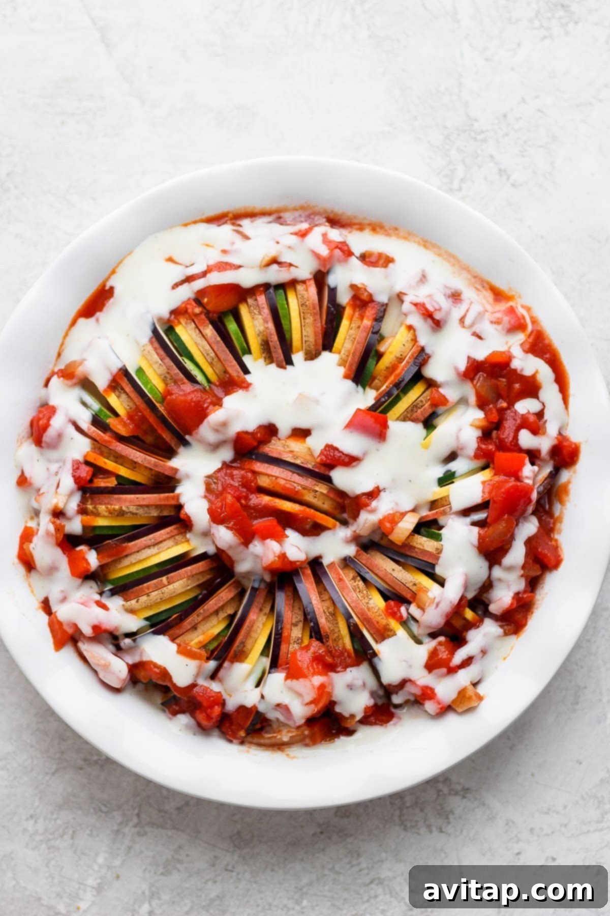 Freshly baked ratatouille, garnished with herbs and cheese, ready to be served.
