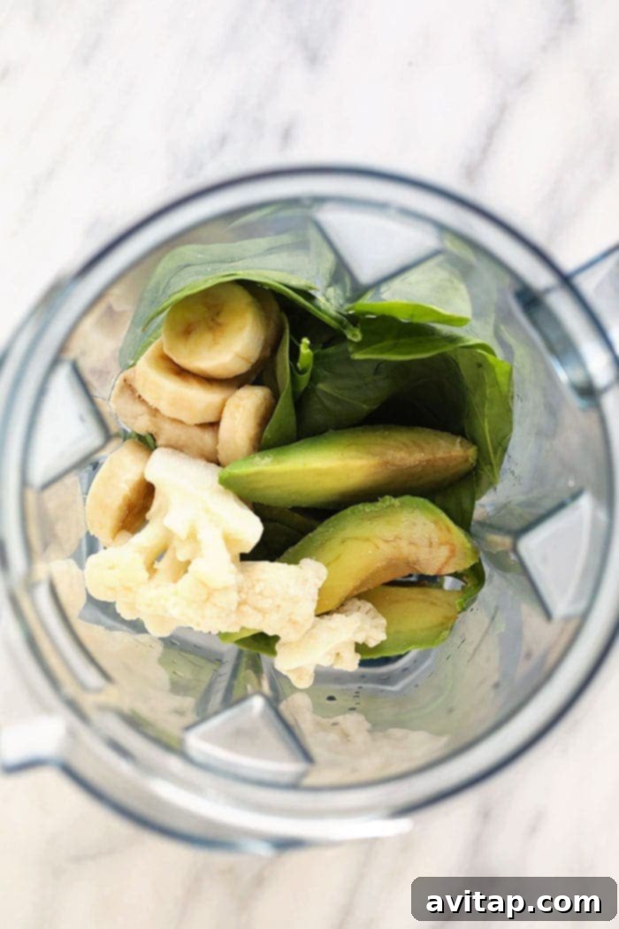 Try using a different kind of green in your green smoothie such as spinach, kale, or arugula! Assorted smoothie ingredients, including spinach, banana, and liquid, in a blender.