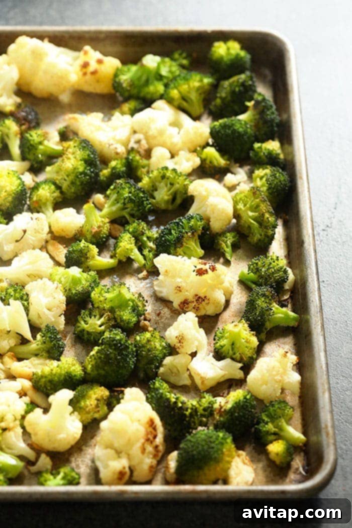 Roasted cauliflower and broccoli on a baking pan with garlic