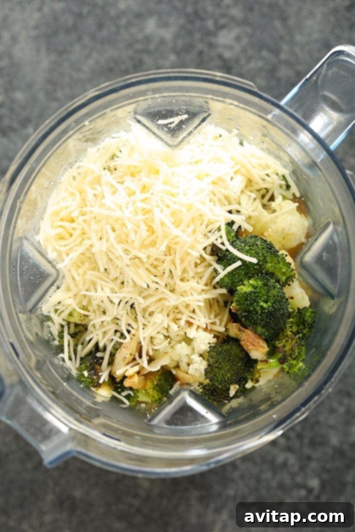 A lightened up broccoli cheese soup being blended in a high-speed blender.
