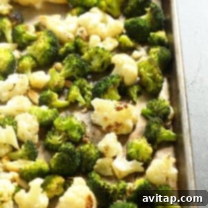 Lightened up roasted cauliflower and broccoli on a baking sheet.