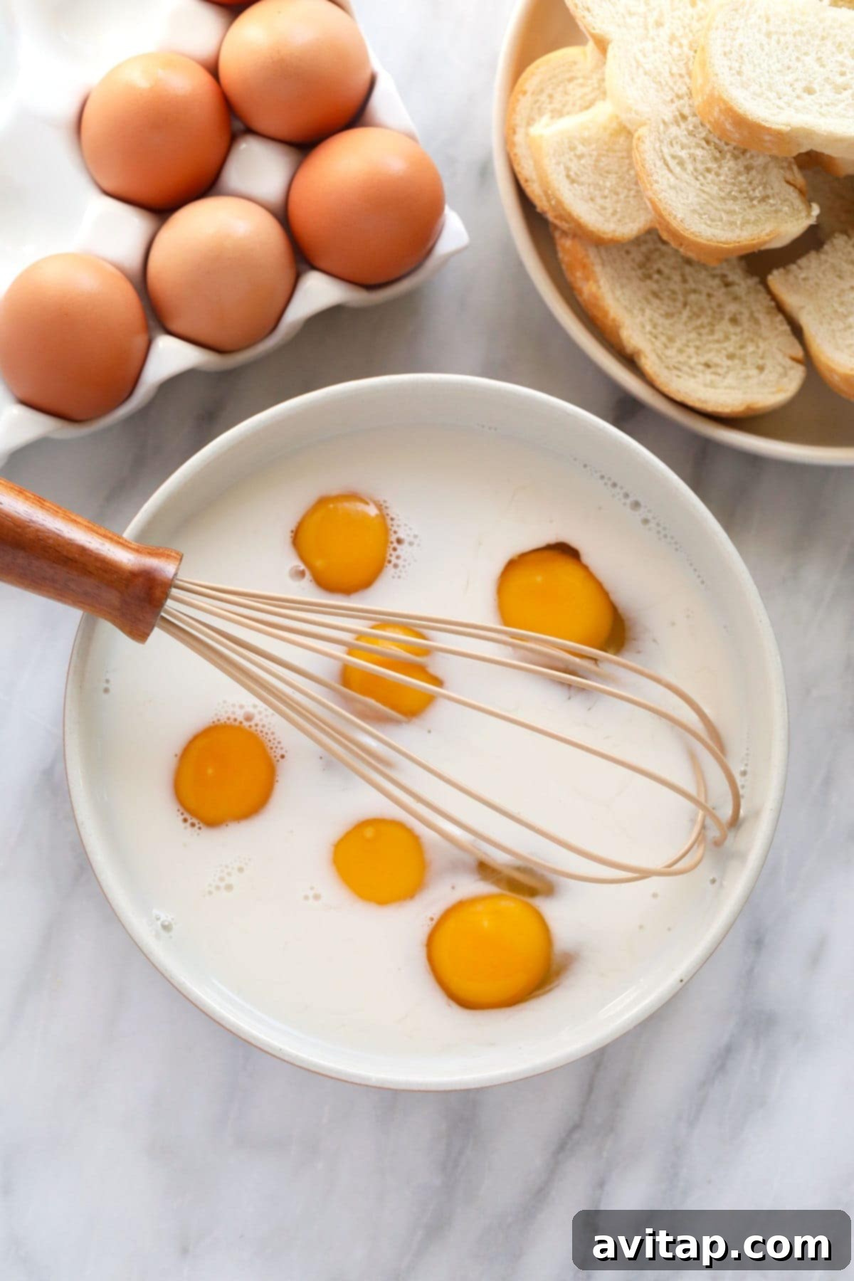 Whisking Egg and Milk for French Toast Batter Ingredients for French Toast Sticks: eggs and milk being whisked in a bowl, a crucial step for the batter.
