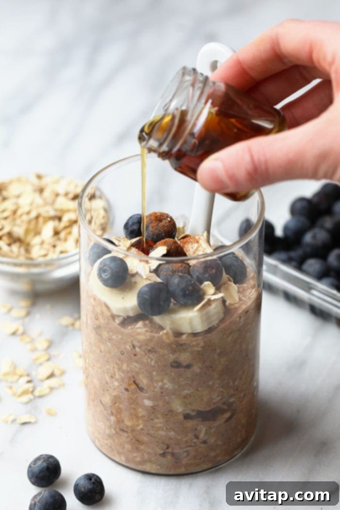 Close-up of Maple French Toast Overnight Oats in a glass jar, garnished with berries.
