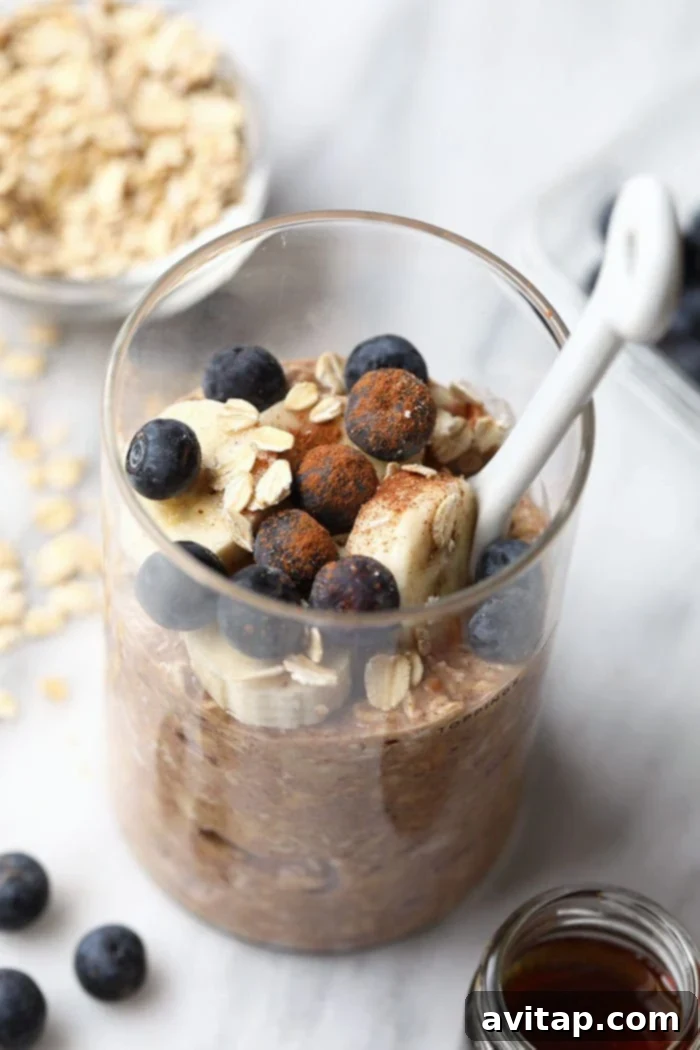 Bowl of Maple French Toast Overnight Oats topped with fresh fruit and a drizzle of syrup.