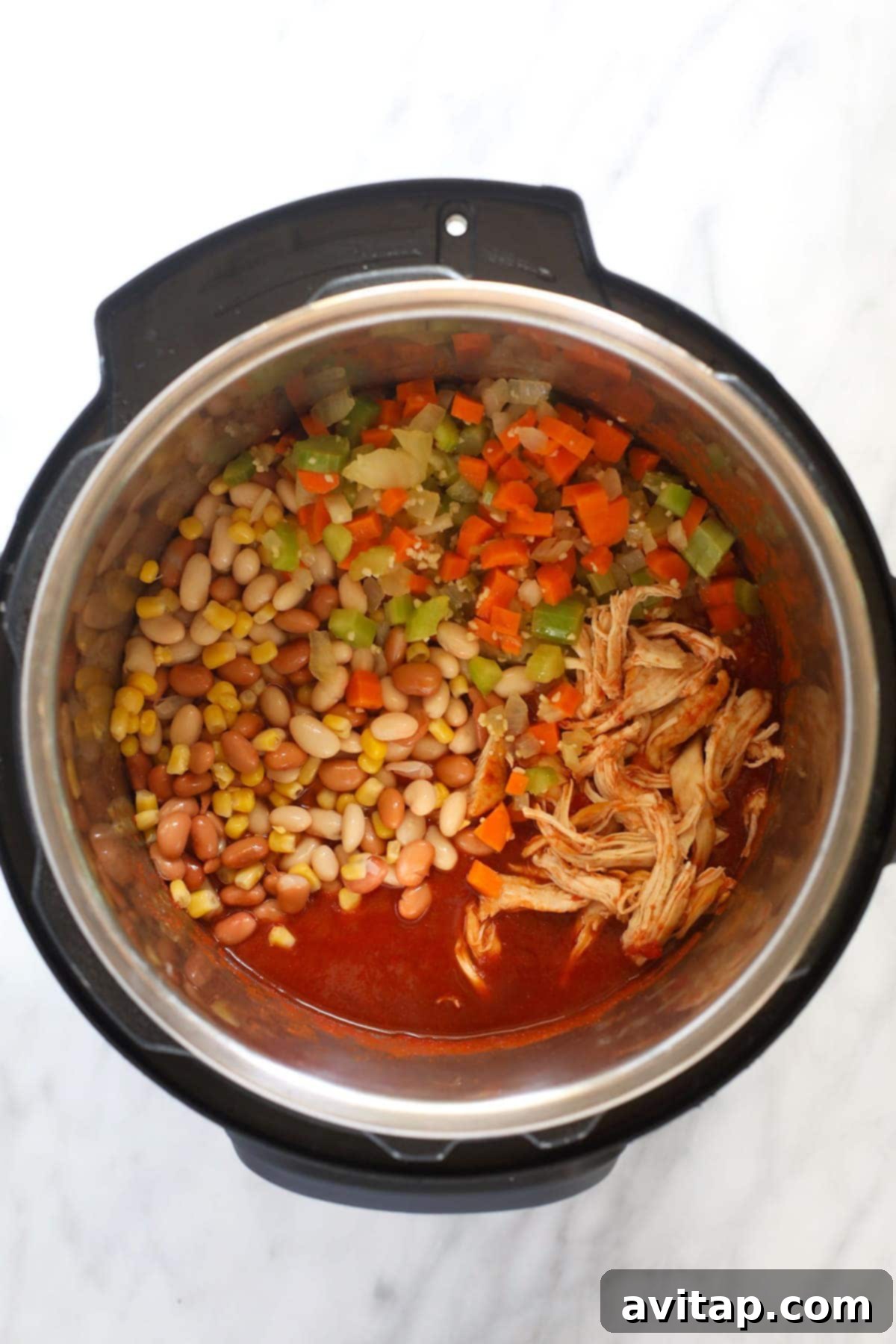 The Instant Pot filled with the rich, simmering buffalo chicken chili, showcasing its hearty texture.