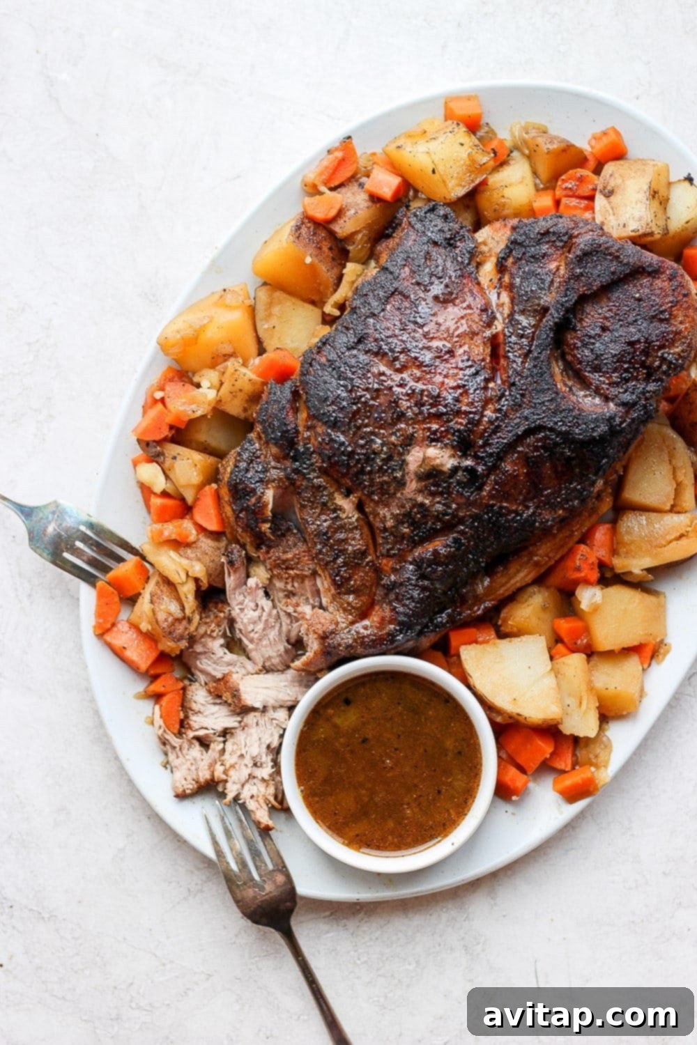 The ultimate oven baked pork roast recipe: crispy pork shoulder, roasted veggies, and homemade gravy for a perfect family dinner. Golden-brown oven baked pork roast surrounded by tender, perfectly roasted potatoes and carrots, glistening with savory drippings, ready to be served.