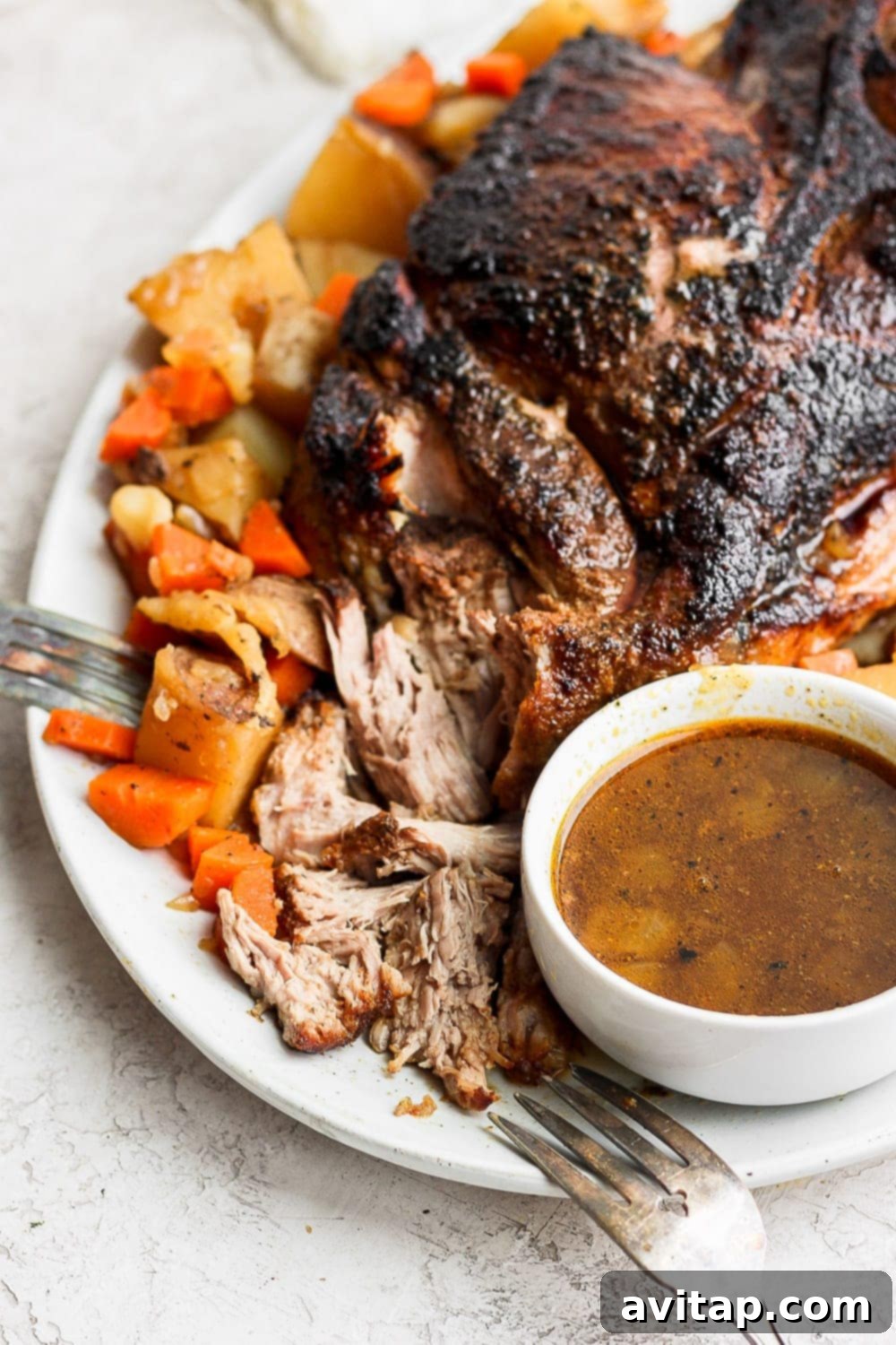 Serve this succulent pork roast with expertly roasted vegetables and a generous amount of homemade gravy for an unforgettable meal. A perfectly cooked, tender pork roast presented on a elegant serving platter, beautifully surrounded by golden-roasted vegetables and generously drizzled with rich, homemade gravy, creating an appetizing and complete meal.