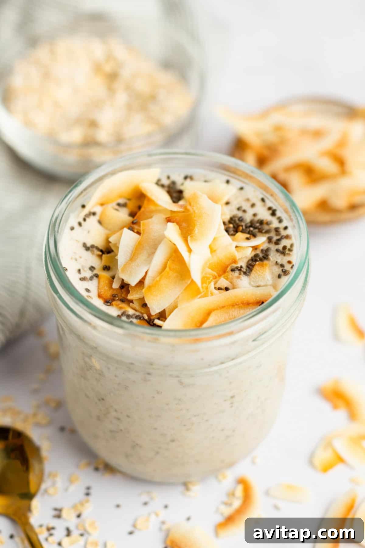 A beautiful jar of creamy Coconut Latte Overnight Oats, topped with toasted coconut flakes and a hint of cinnamon, perfect for a healthy breakfast.