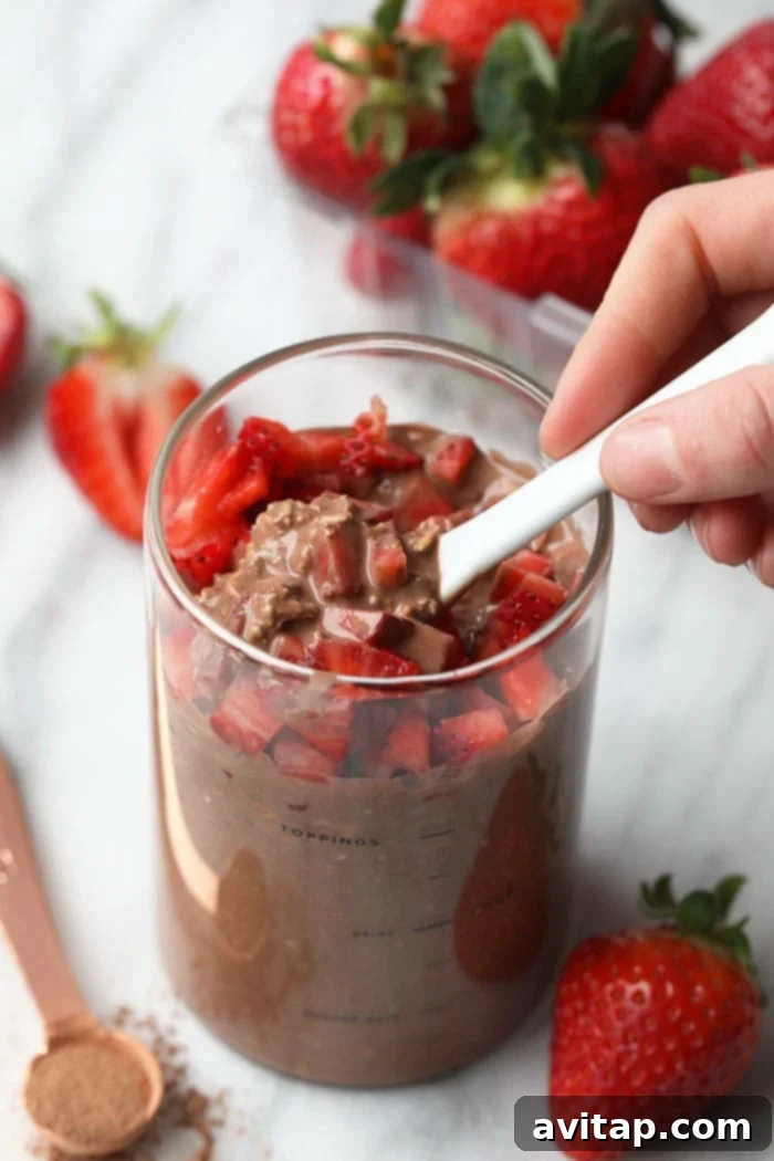 Close-up of overnight oats with chocolate and strawberries, beautifully arranged in a glass jar.