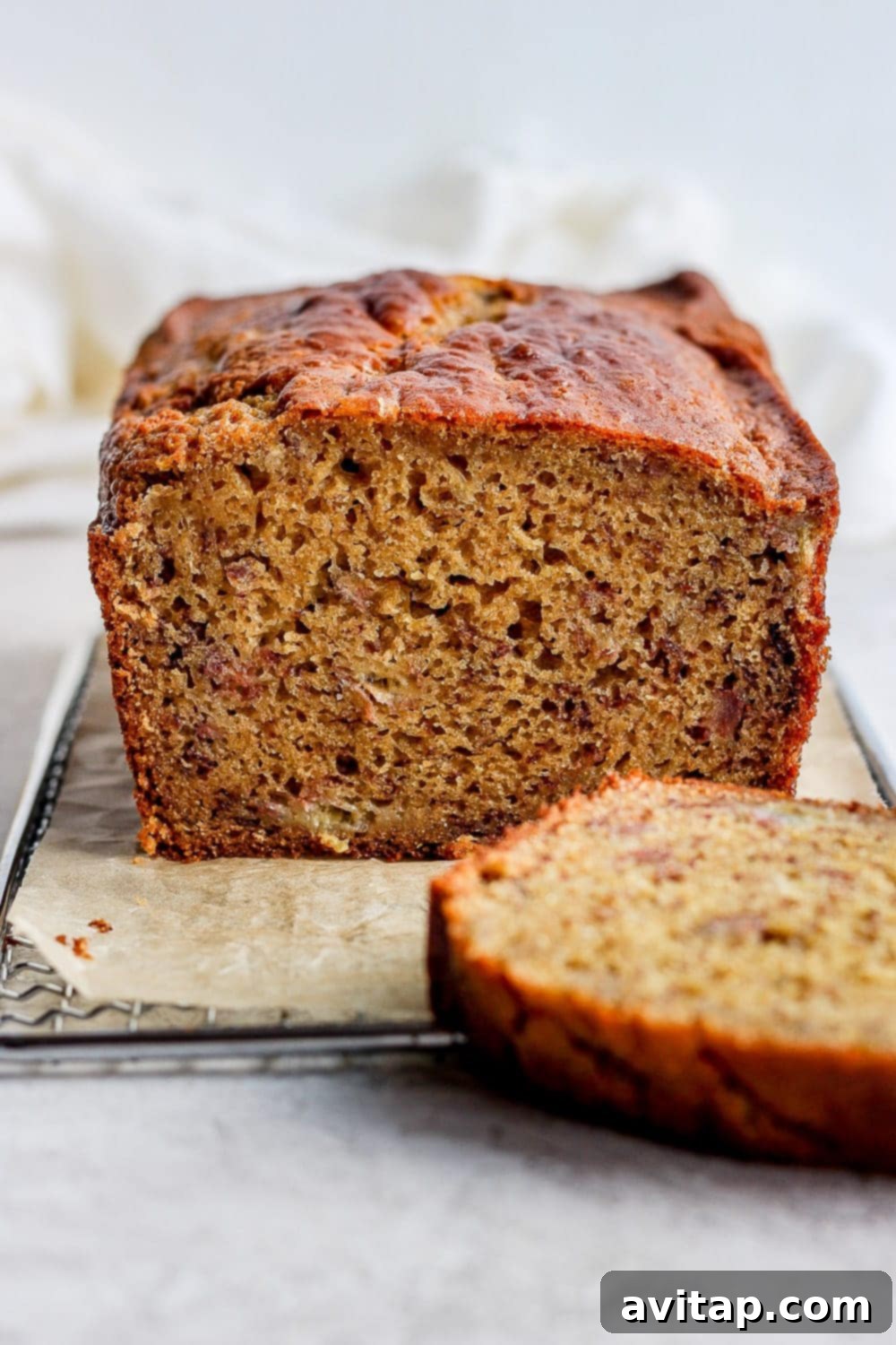 The Best Healthy Banana Bread: 100% Whole Grains, Natural Sweeteners, and Coconut Oil A perfectly baked loaf of healthy banana bread with a slice cut out, showcasing its moist, golden-brown interior.