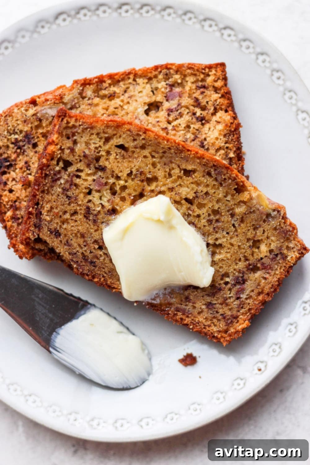 Delicious Healthy Banana Bread with Butter: The Perfect Wholesome Treat A delicious slice of healthy banana bread topped with a generous spread of butter, perfect for breakfast or a snack.
