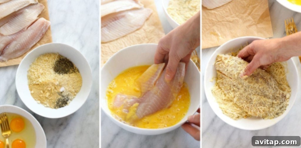 The step-by-step process of coating raw tilapia fillets with the Parmesan and cornmeal mixture, showcasing a uniform, ready-to-bake texture.