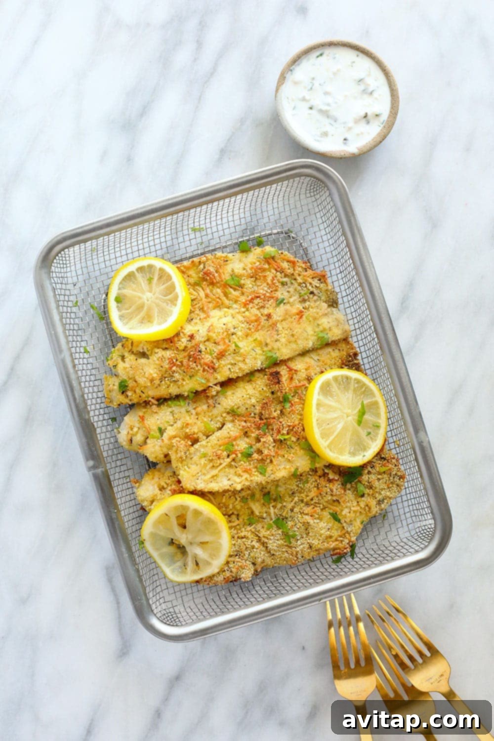 Perfectly baked Parmesan crusted tilapia fillets arranged attractively in a serving basket, garnished with fresh lemon slices and herbs, ready for a delicious meal.