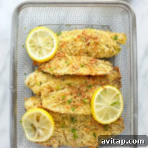 Parmesan tilapia in a basket, ready to be served, garnished with fresh herbs.