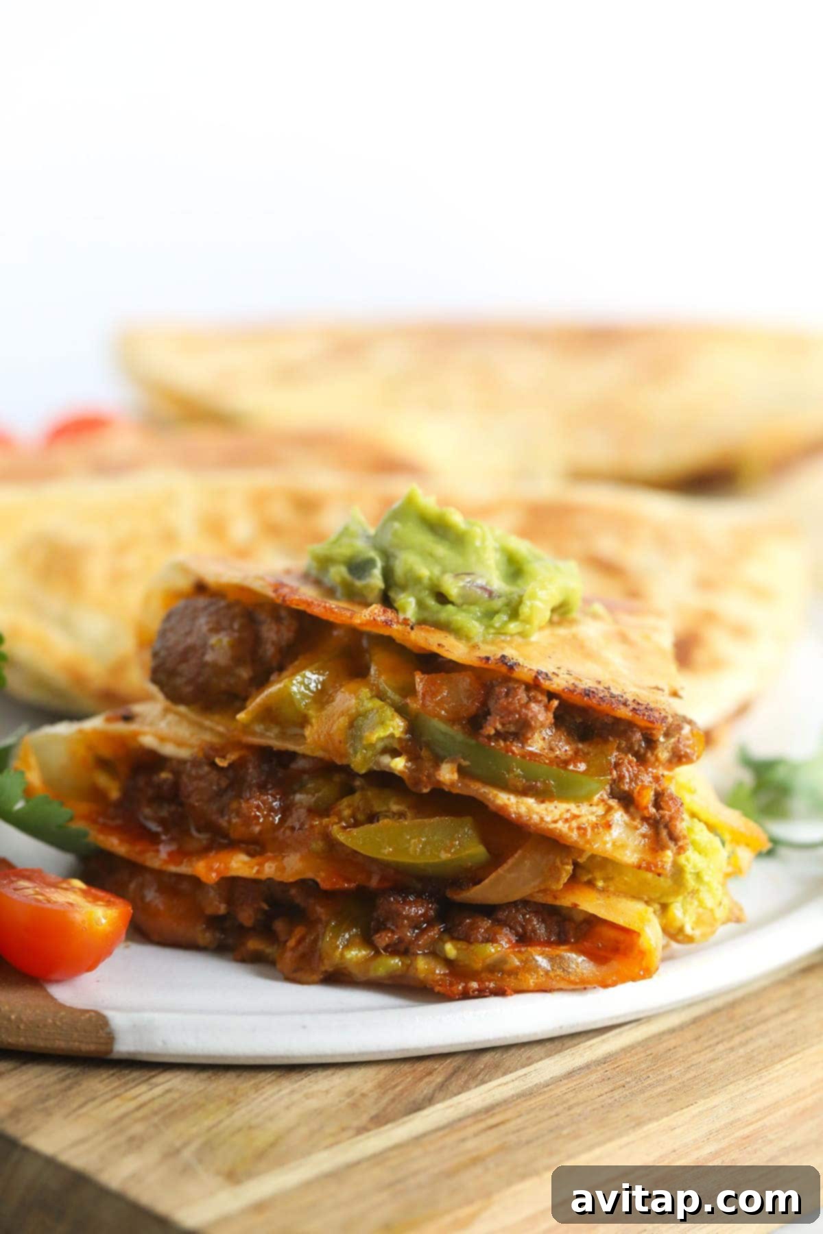 Best Chicken Quesadillas – Quick and Easy Weeknight Meal Crispy chicken quesadilla topped with fresh guacamole and a sprinkle of cilantro, ready to be served.