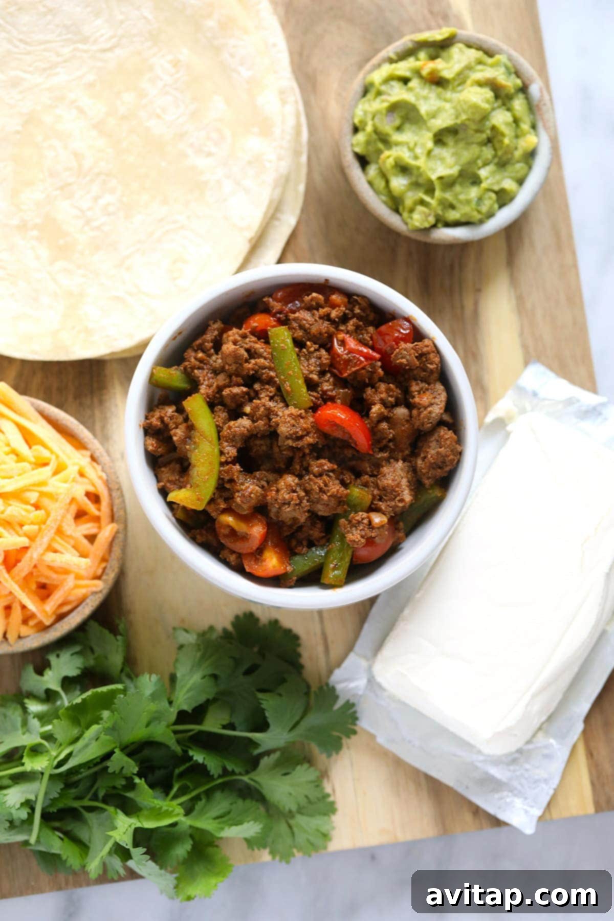 Essential Ingredients for Delicious Chicken Quesadillas Fresh ingredients for chicken quesadillas laid out on a cutting board, including diced onions, bell peppers, ground chicken, and tortillas.