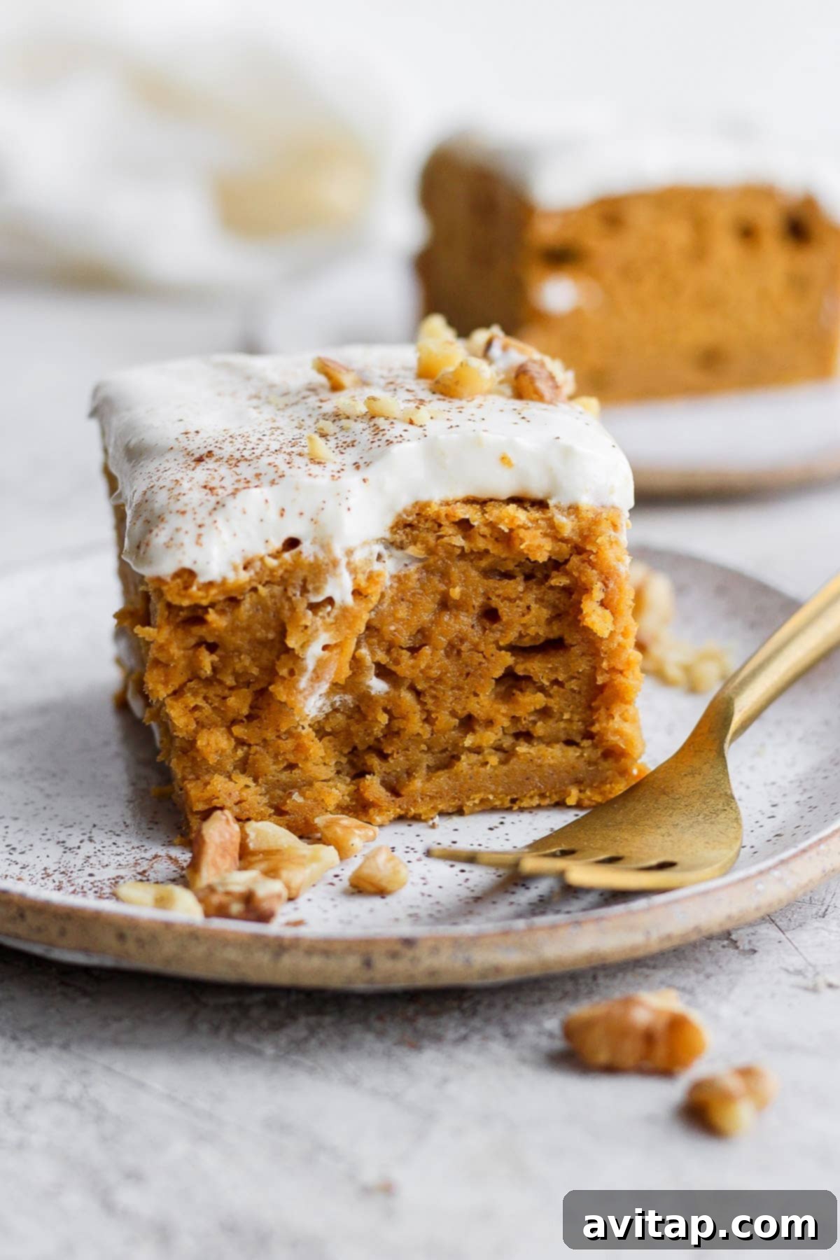 A delectable slice of pumpkin sheet cake adorned with creamy frosting, resting on a plate, ready to be enjoyed.