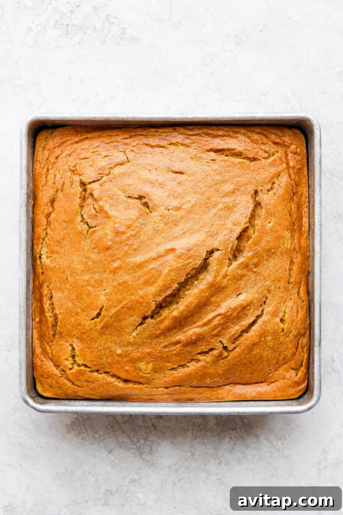 A freshly baked pumpkin sheet cake, golden brown and perfectly risen, just out of the oven.