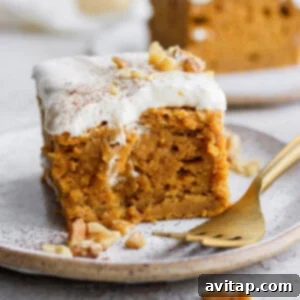 A beautiful slice of pumpkin sheet cake on a plate with creamy frosting.
