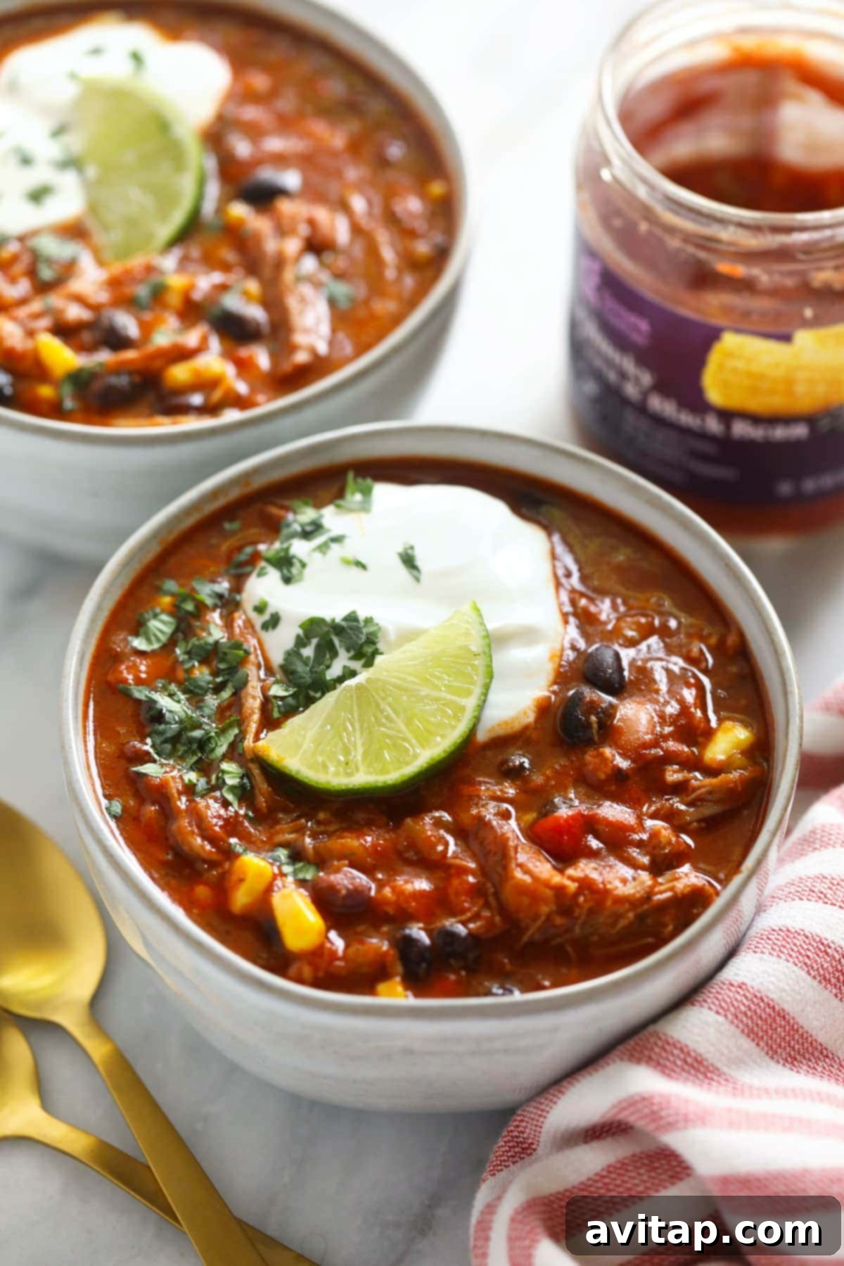 A bowl of thick, flavorful Instant Pot Pork Chili topped with a dollop of Greek yogurt and a fresh lime wedge, ready to be enjoyed.
