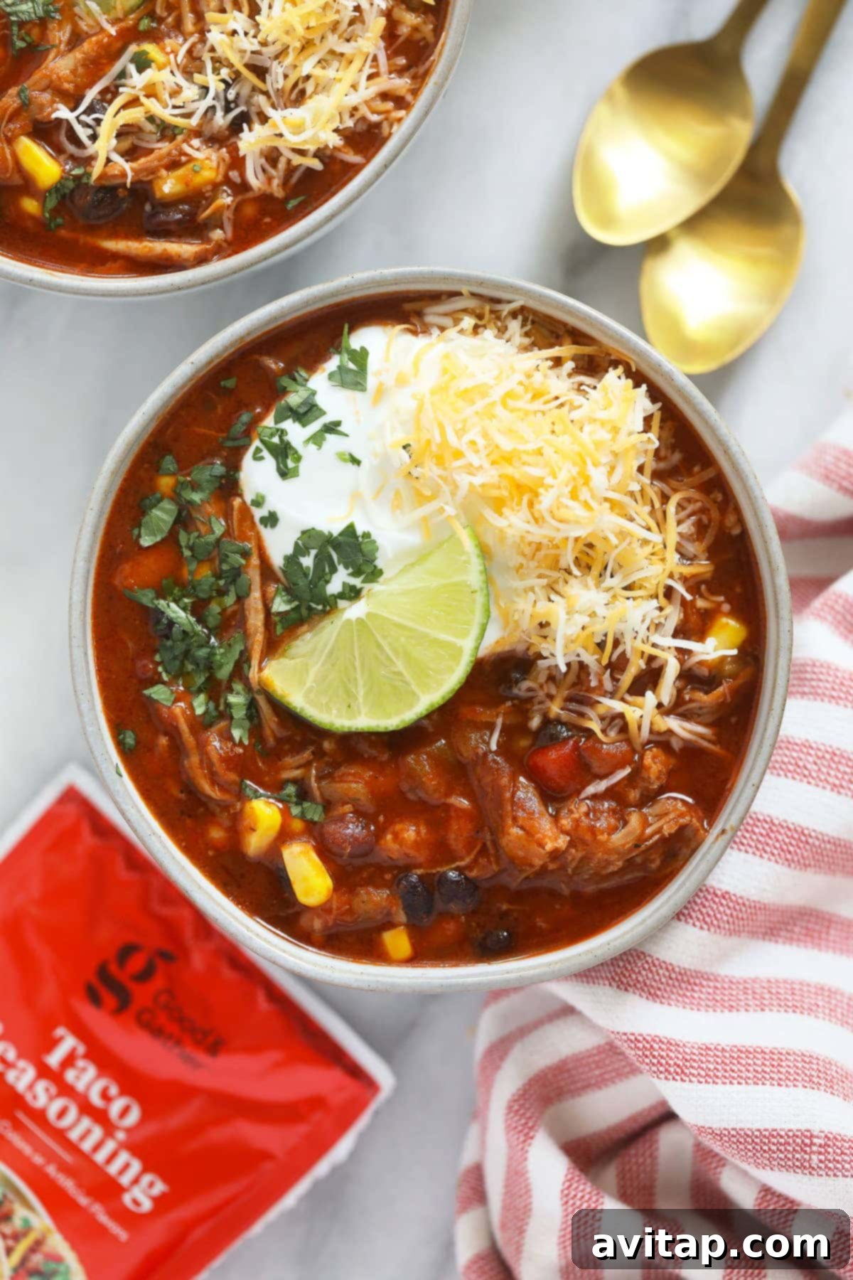 A close-up of Instant Pot pulled pork chili in a bowl, garnished with a fresh lime wedge.