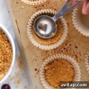 a person pouring granola into a muffin tin.