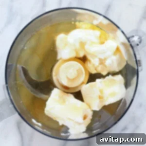a food processor filled with butter and bananas.