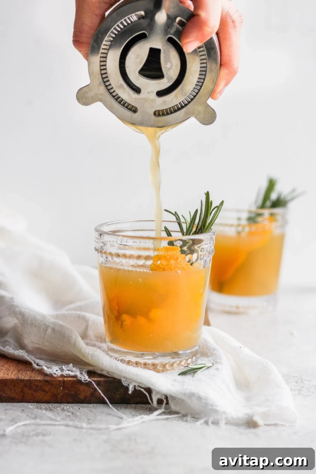 Individual ingredients for an Apple Cider Cocktail, including rye whiskey, apple cider, and fresh oranges.