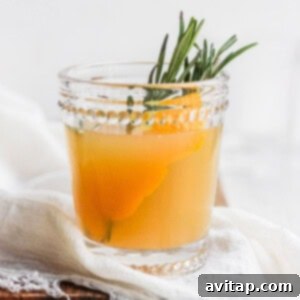A perfectly prepared Apple Cider Cocktail in a glass with rosemary.
