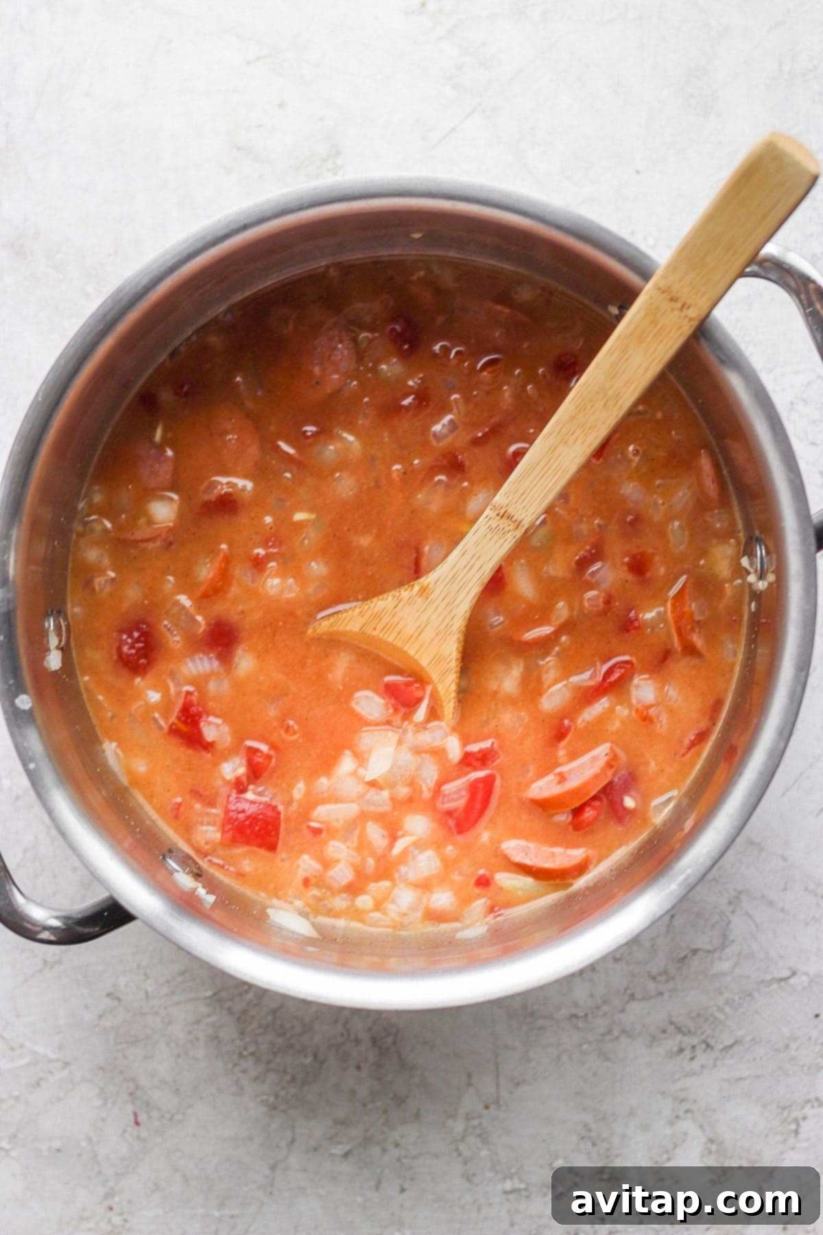 A large stockpot filled with the aromatic broth for the seafood boil, simmering with spices and aromatics.