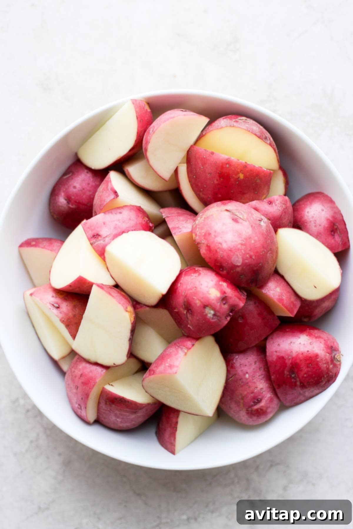 Red potatoes prepared for roasting with ranch seasoning Sliced red potatoes ready to be tossed in ranch and roasted